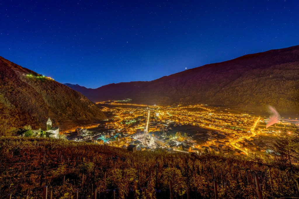 Ciudad alpina iluminada de noche vista desde lo alto